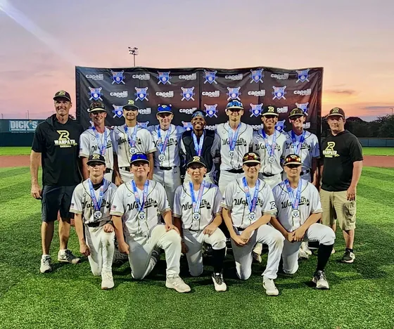 A Warpath team with medals in front of a tournament backdrop