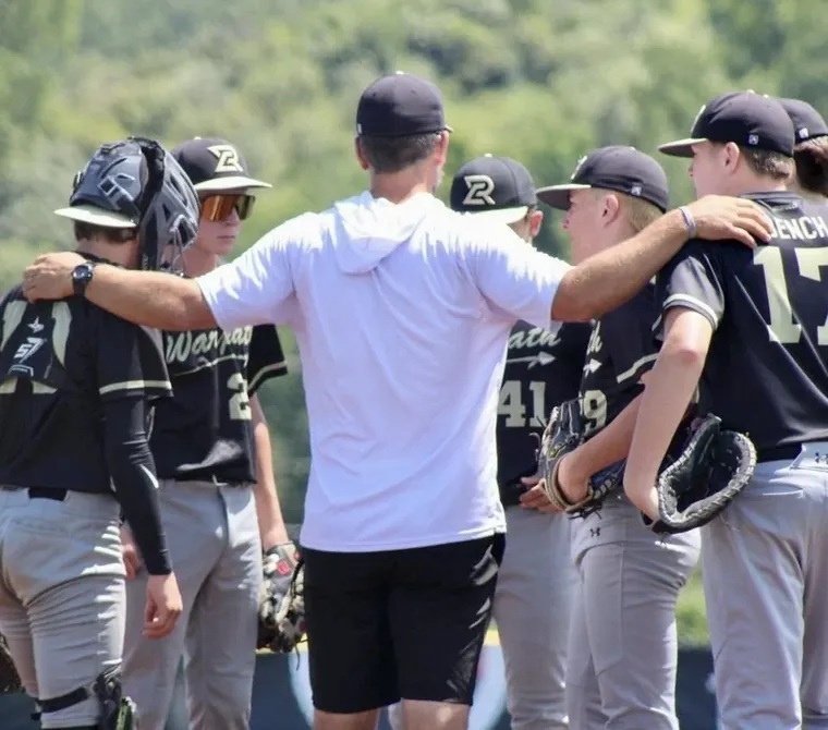 Warpath players in a huddle with their coach