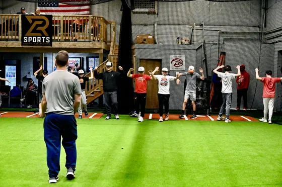 A coach leading a group warm-up at RCS Academy