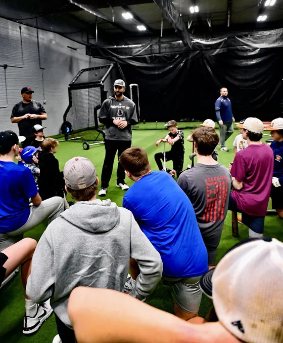 A coach addressing players on the turf at RCS Academy