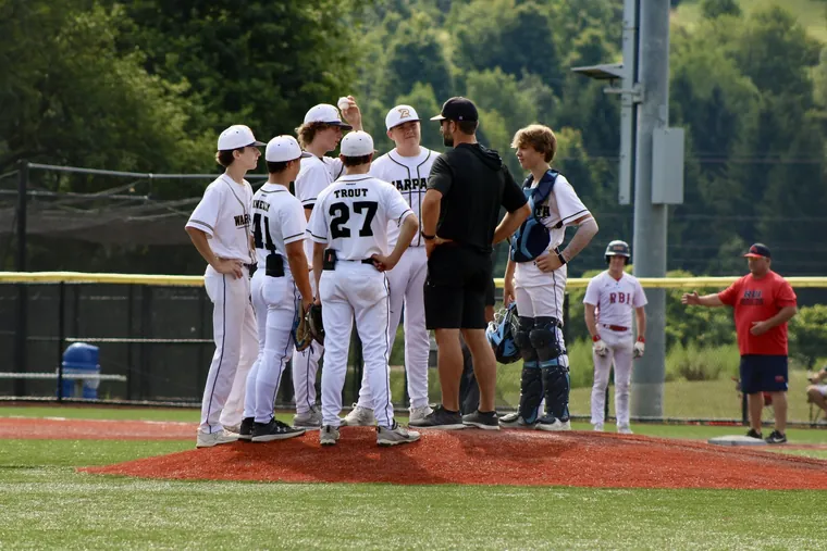 A Warpath coach meeting his players on the pitcher’s mound during a game